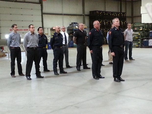 14 men stand at attention during a drill to try out for Honour Guard.