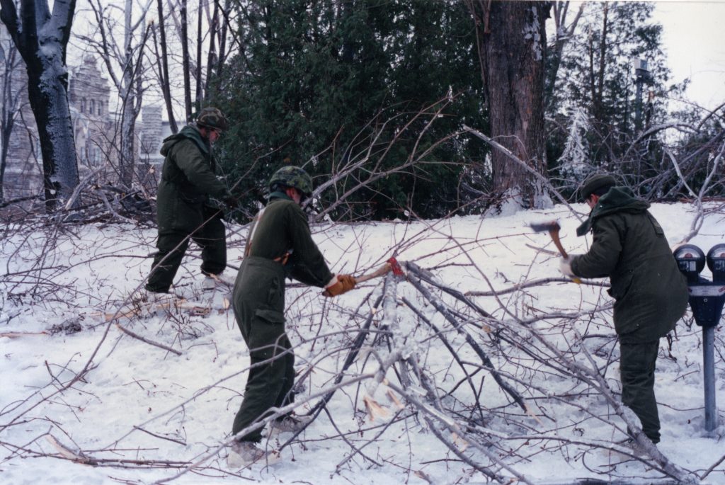 The military using axes to break branches, to then clean them up.