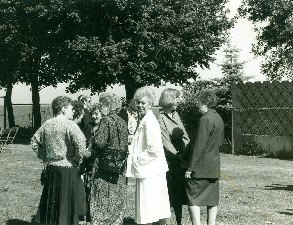 Black and white photograph of a group of women talking outdoors