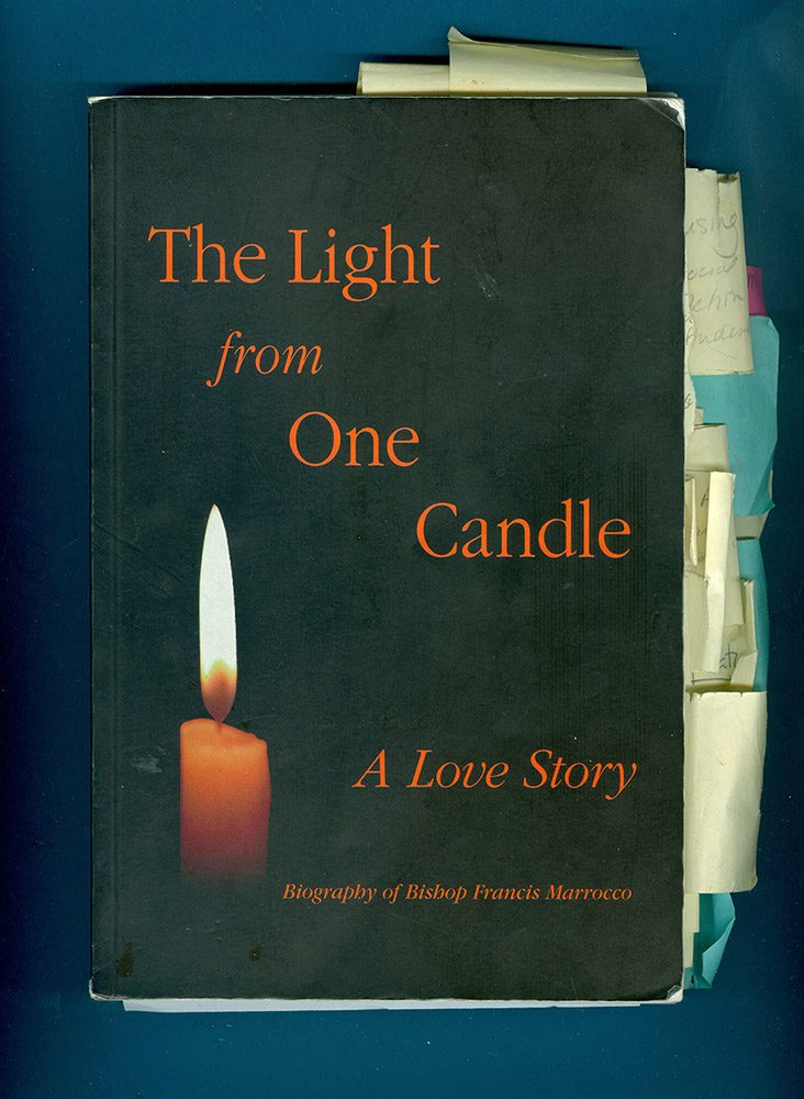 Colour photograph of a book cover "The Light from one Candle: A Love Story - Biography of Bishop Francis Marrocco" There are many note cards attached to the book