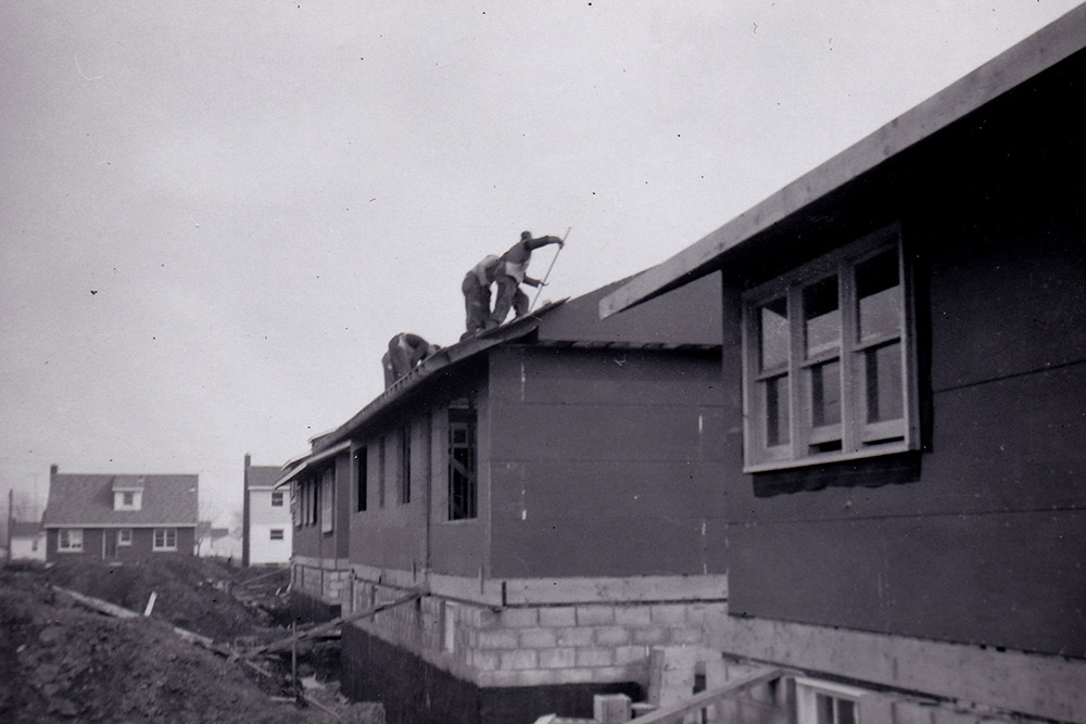 Black and white photograph of men working on a roof