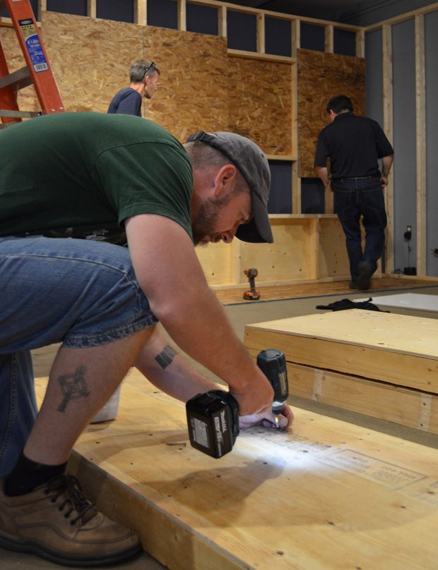 Colour picture of a person using a drill building a platform