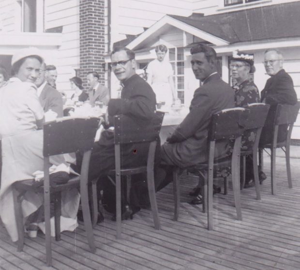 Black and white photograph of people sitting at a table