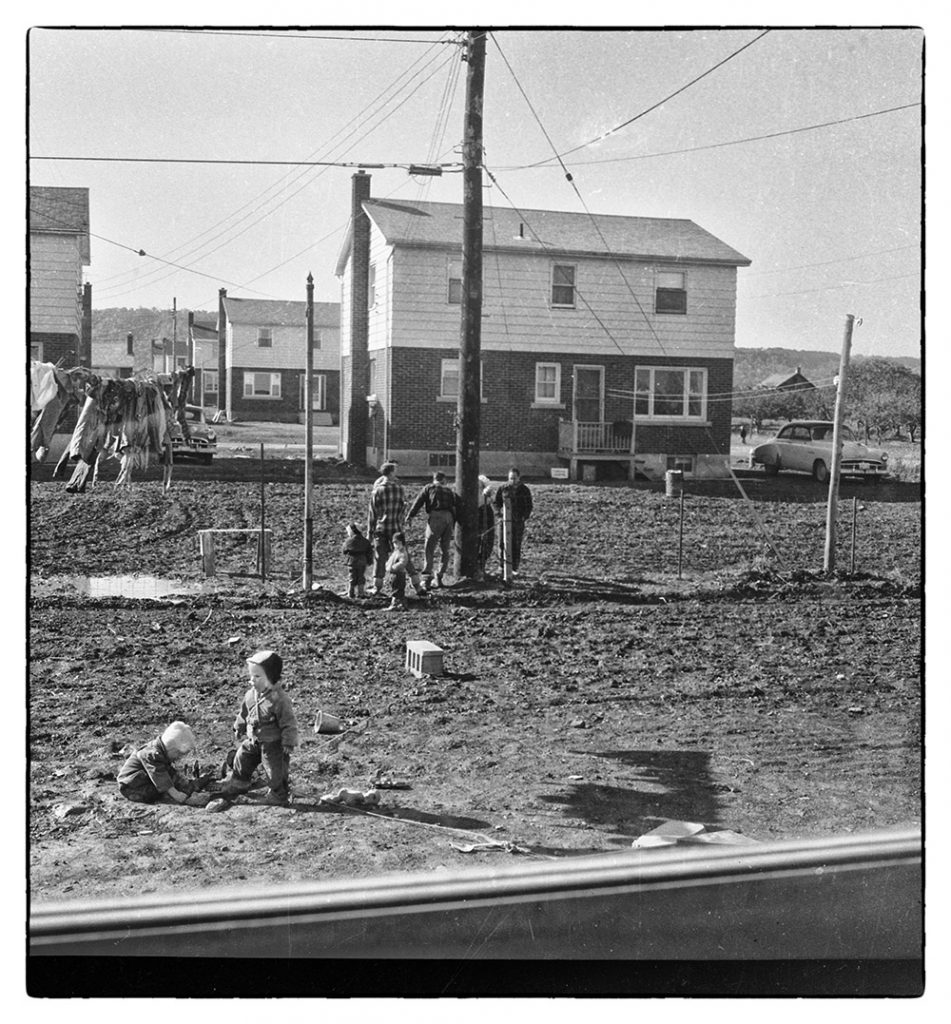 Black and white photograph of some people at a housing construction site