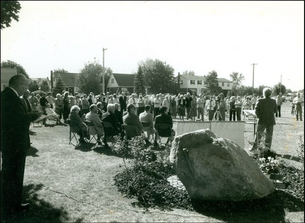 black and white photograph of a gathering of people in a park
