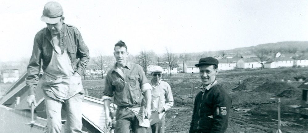 Black and white photograph of a group of four men on a roof