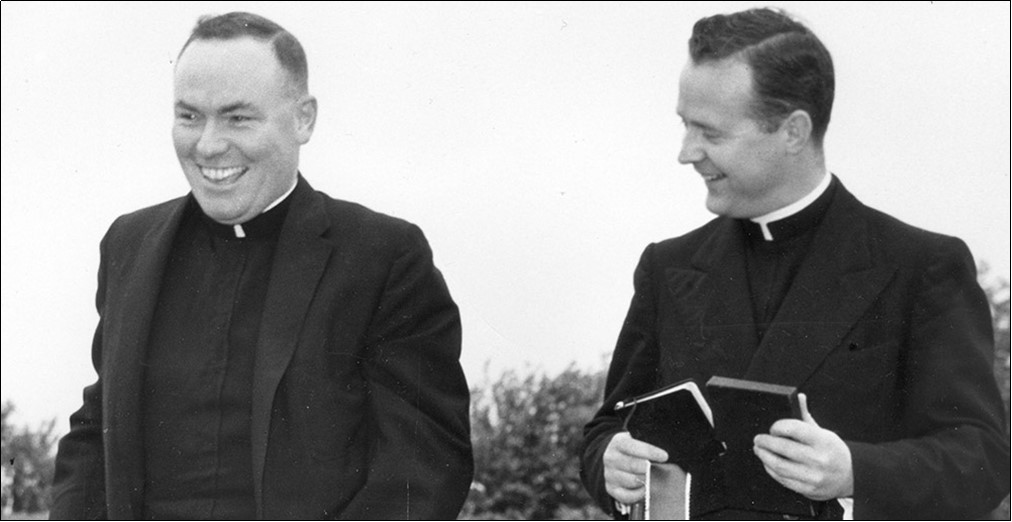 Two priests Father Sherlock and O’Brien standing side by side, smiling.
