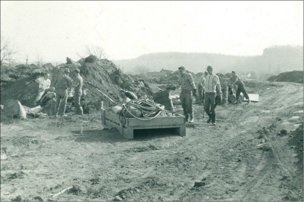 Black and white photograph of men clearing land for building
