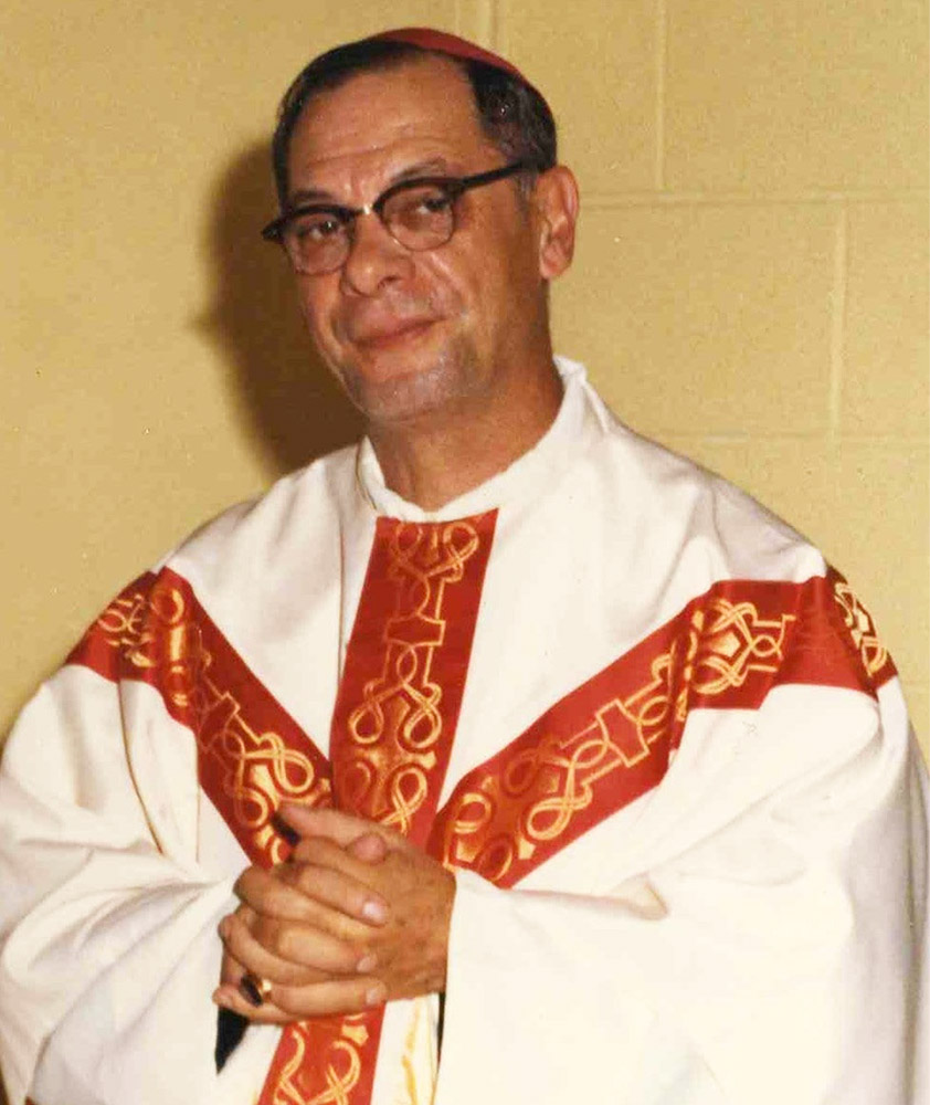 Colour photograph of a priest wearing white and red