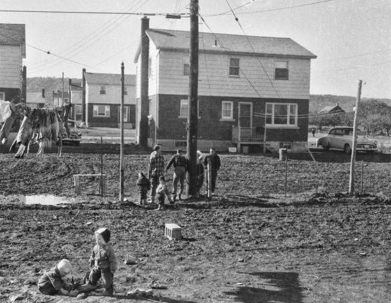 Black and white photograph of some people at a housing construction site