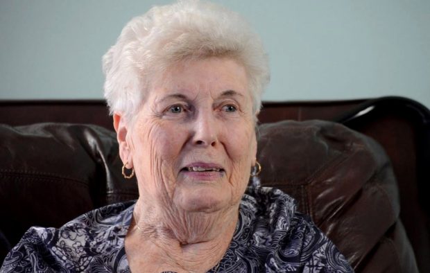 Colour close up photograph of a woman in a chair