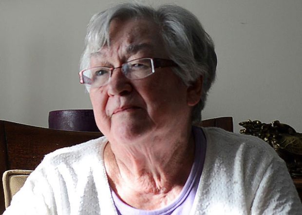 Colour close up photograph of a woman in a chair