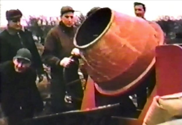 colour photograph of three men around a cement mixer