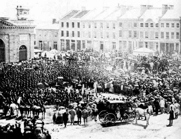 Period photograph of a crowd of people attending the proclamation of Confederation in Kingston's Market Square, 1867