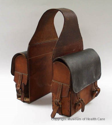 Sac de selle de médecin en cuir. Deux sacoches carrées sont reliées ensemble par une sangle de cuir se plaçant par dessus le cheval.