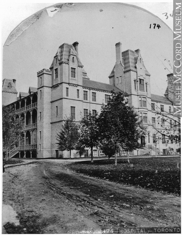 Photograph of Toronto General Hospital in 1868 with a roadway and trees in front of the building