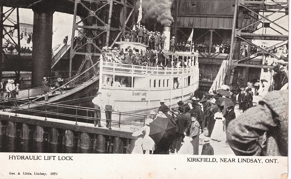 Black-and-white image of steamboat in lift lock with crowds of people looking on