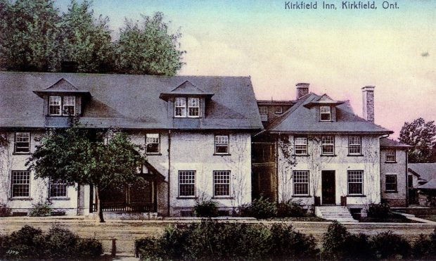 Colour image of building covered in vines with road in foreground