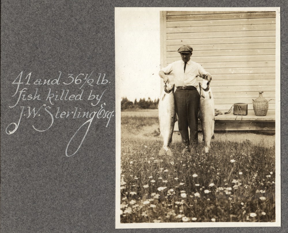 Silver print of John W. Sterling showin two spectacular salmon.