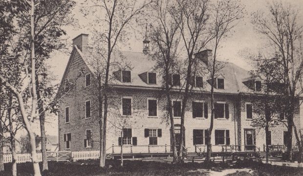 Black and white photograph of the three-storey convent of Sainte-Anne with shuttered windows and gabled roof with small bell tower in the center and six dormers.