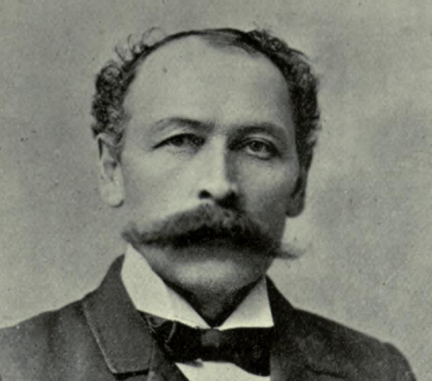 Black and white photograph of Jeffrey Alexandre Rousseau wearing a mustache and dressed in a suit with bow tie.