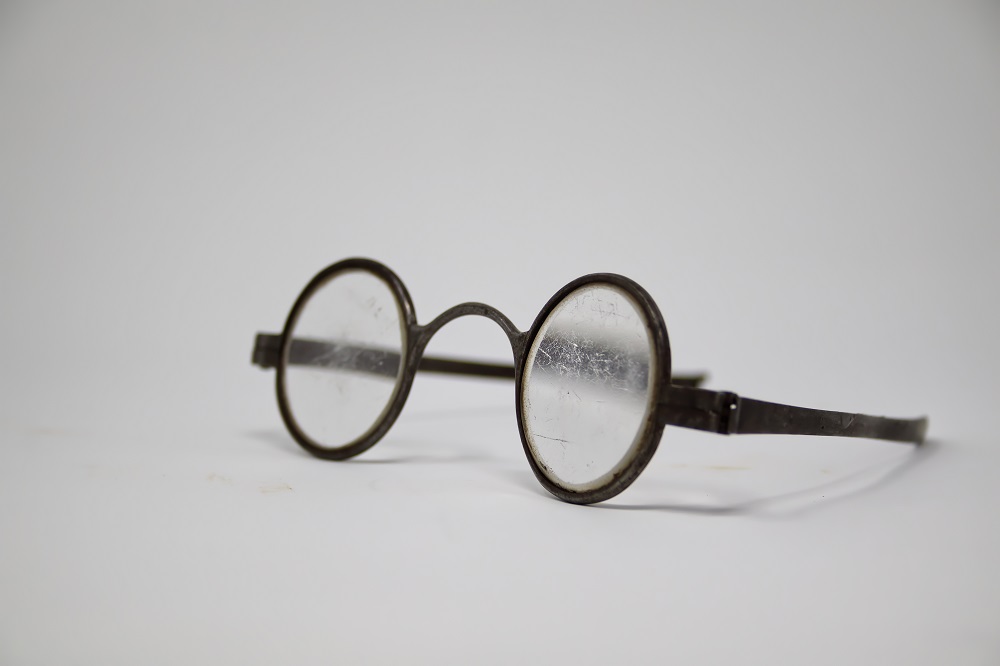 Photograph of round metal and glass spectacles used in the time of New France.