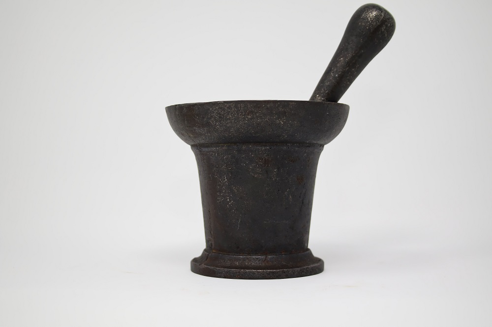 Photograph of a metal and cast-iron pestle and mortar.