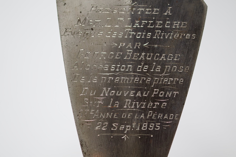 Close up of the trowel’s metallic part with the inscription Presented to Monsignor L.F. Laflèche, Trois-Rivières’s Bishop by George Beaucage on the occasion of the laying of the new bridge’s first stone on the Sainte-Anne de la Pérade River September 22 1895.