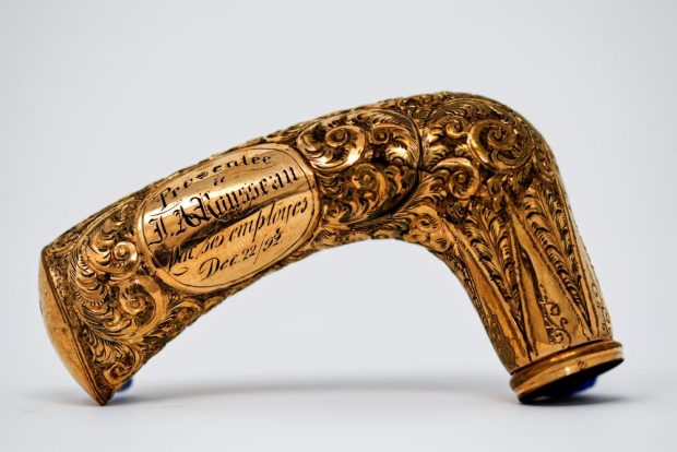 Metal knob of a cane adorned with acanthus leaves and carved with the inscription Presented to J A Rousseau by his employees Decembre 22/92.