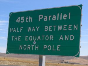 Photo of a road sign stating “45th Parallel, half-way between the equator and the North Pole.”
