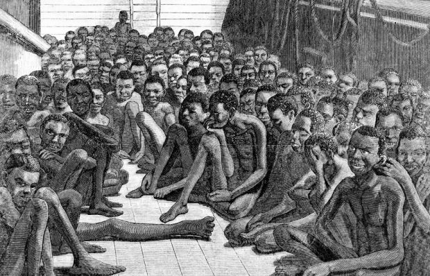 Engraving of the deck of a ship where dazed black slaves cling together.