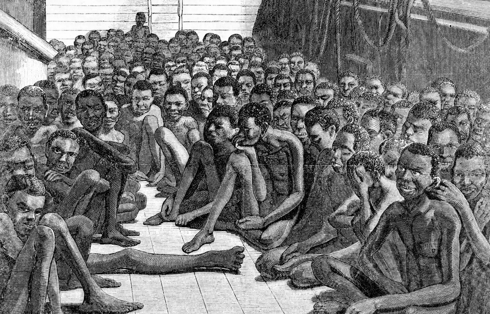 Engraving of the deck of a ship where dazed black slaves cling together.