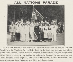Svarthvít ljósmynd af hópi Íslendinga og Íslendinga af kanadískum uppruna í skrúðgöngu All Nations Parade í Winnipeg þann 4. júlí 1942. Hópurinn samanstendur af körlum og konum, sumum í hefðbundnum íslenskum klæðnaði, safnaðir í kringum íslenska fánann.