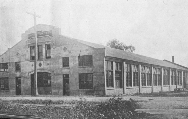 Black and white photograph of a large industrial brick building on Cutting Street in Coaticook. The inscription A. O. Norton LTD is on the front of the building.