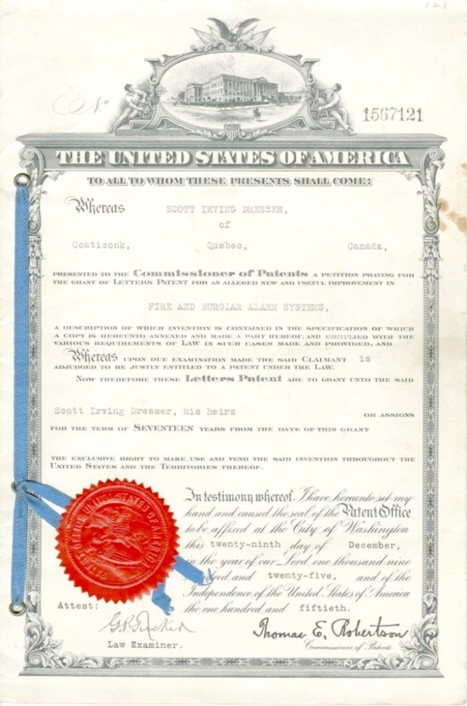 Colour photograph of a patent with a red seal granted to Scott Irving Dresser, for the invention of an alarm system dating from 1925. The official document is issued from the United States in English.
