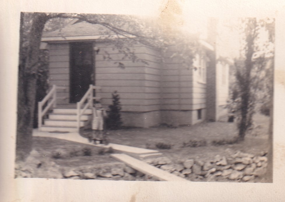 Boy standing in front of a house