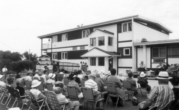 Group of people sitting on chairs outside a building