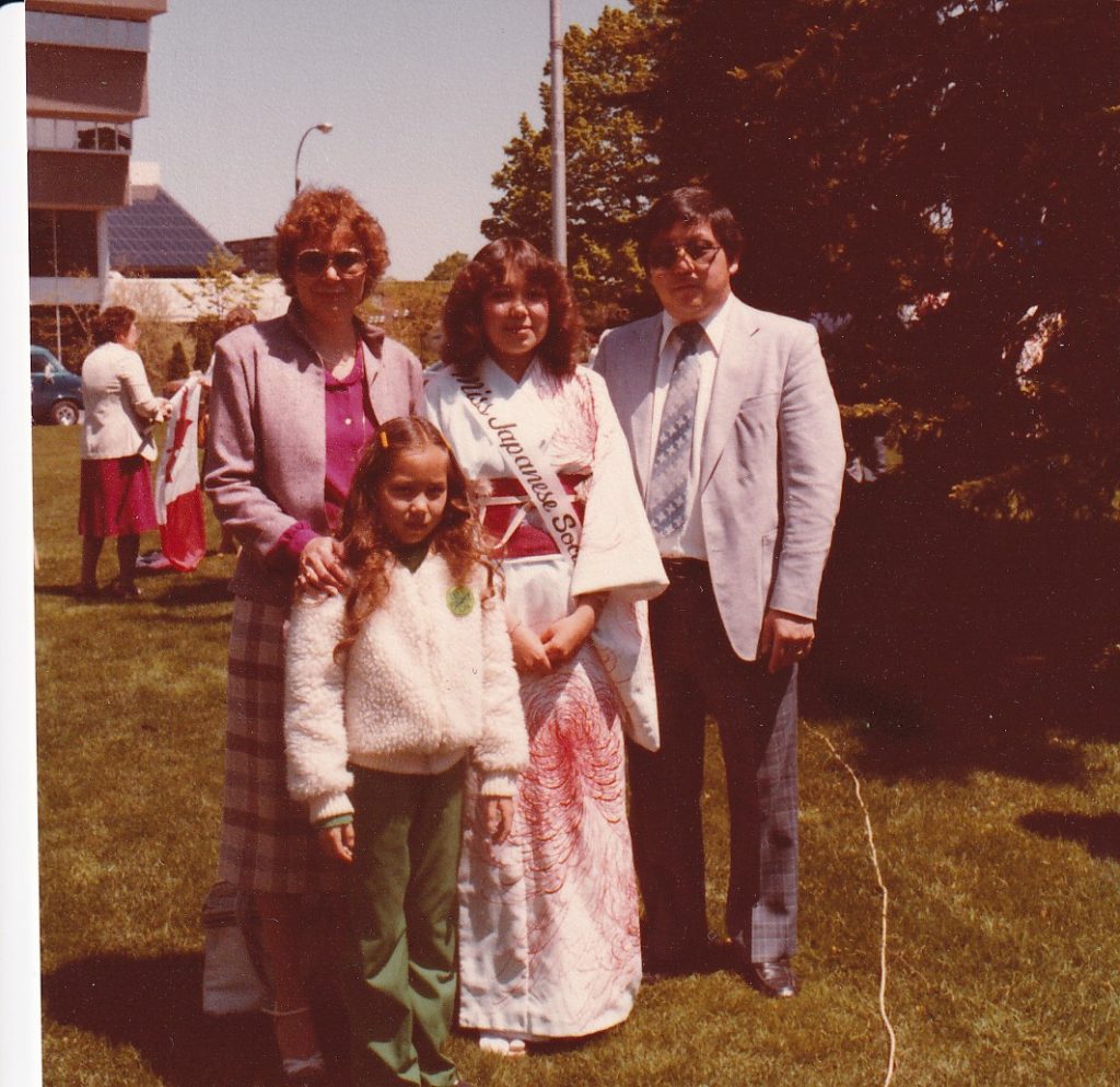 Ken Teshima with his wife and children, with his eldest daughter wearing a sash with 