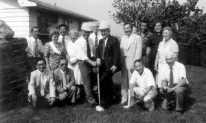 A group of Japanese men and women posing near the site of the groundbreaking of the Nipponia Home