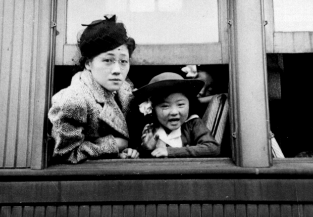 Woman and young girl learning out of a train window