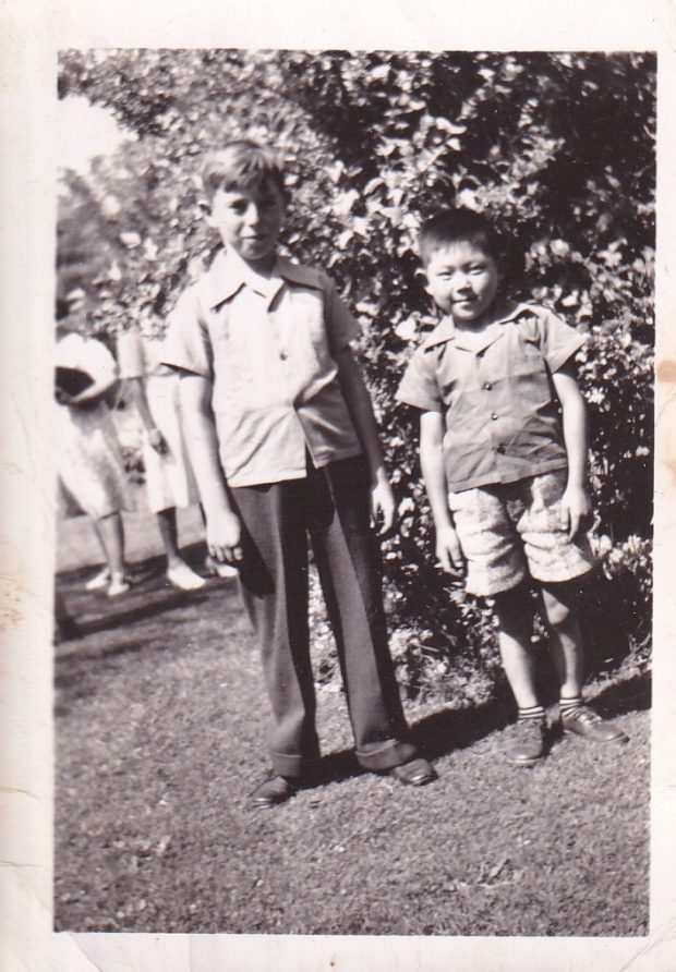 Two young boys standing outside together
