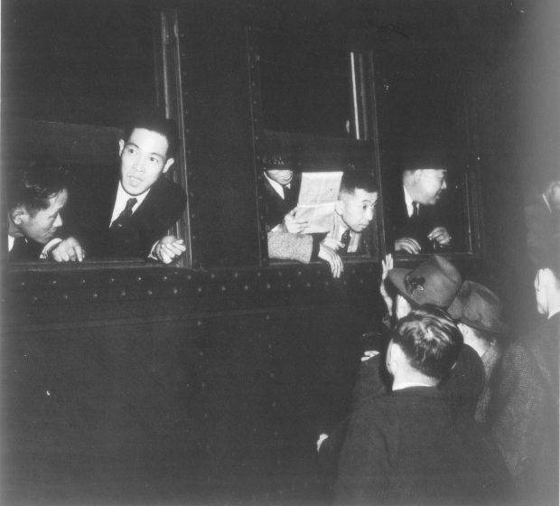 Japanese Canadian men leaning out the window of a train