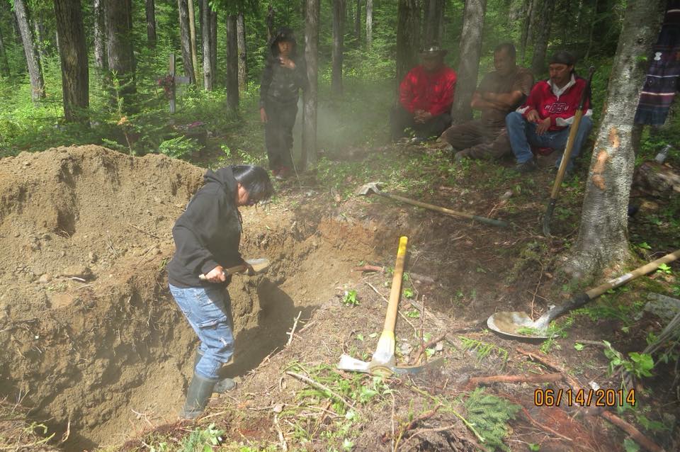 Anicinabek people dig a grave at the family cemetery in the woods.