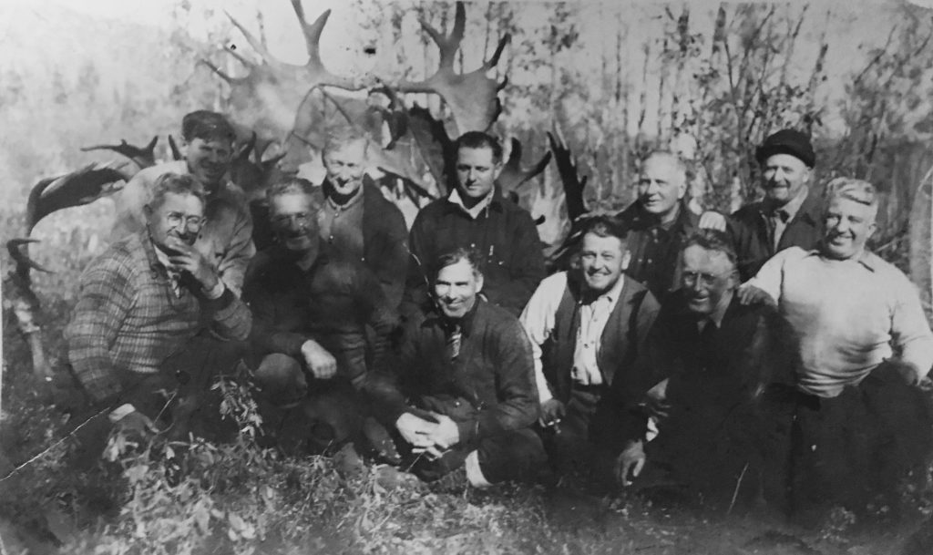 Group of non-indigenous hunters and their trophy (moose plume).)