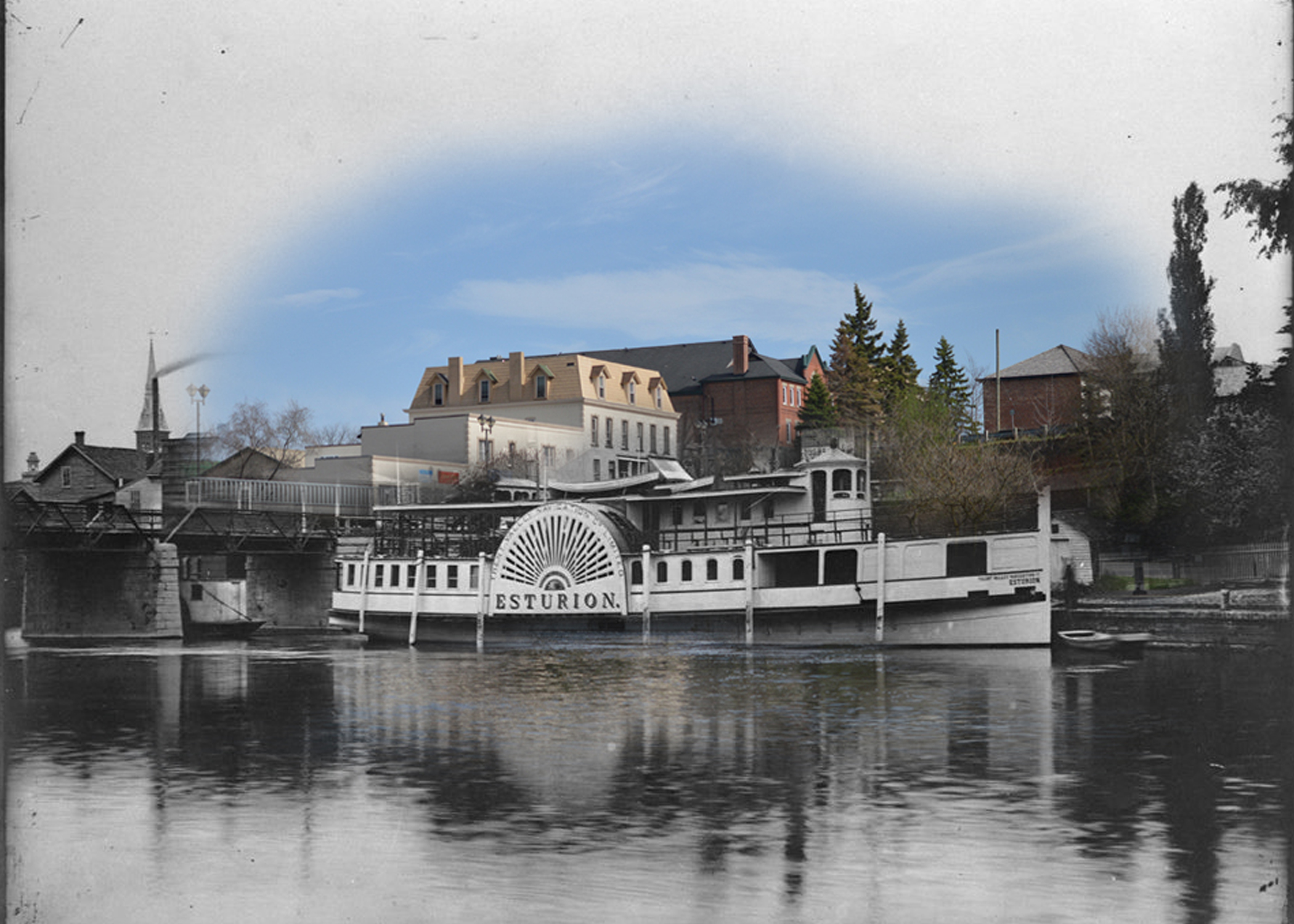 A black and white photograph of a steamboat superimposed on a contemporary image of a streetscape.