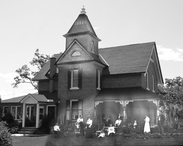 Superimposed B&W photos of a brick home with a prominent tower. Historic photo shows gathering of people on the on the lawn.