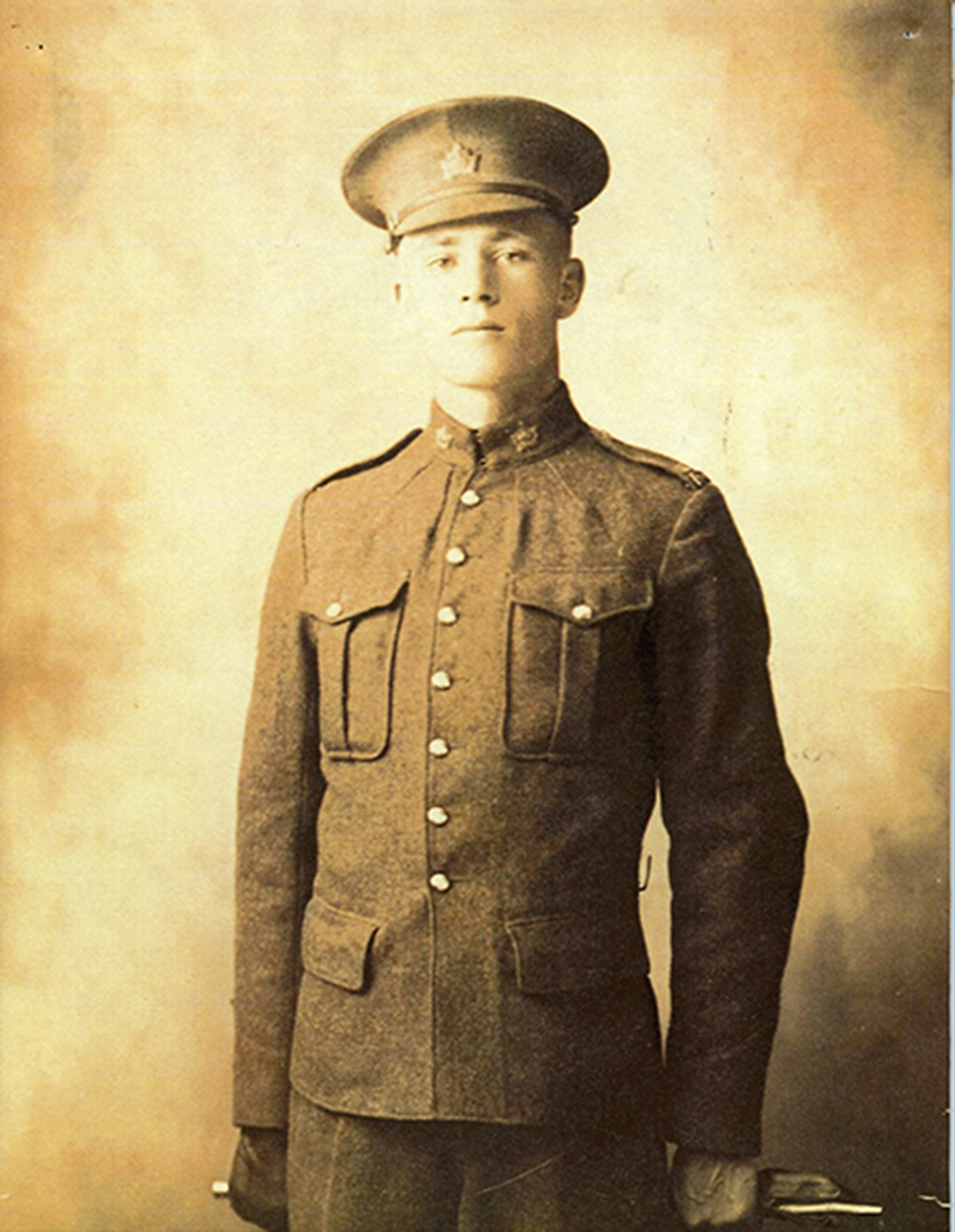 A yellow-tinted black and white picture of a soldier in a uniform looking resolutely at the camera.