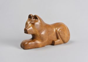 Sculpture d’un loup stylisé en pierre de savon, de couleur rouille et au fini très lisse.