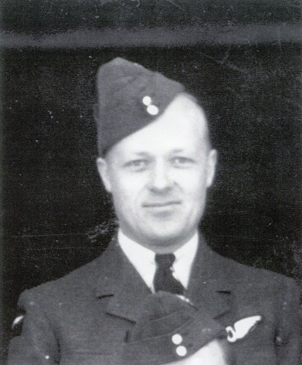 A black and white grainy photograph of a soldier wearing a Royal Canadian Airforce uniform smiling at the camera.