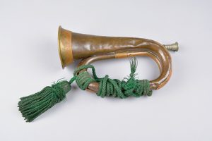 A brass bugle with a green rope tassel attached.